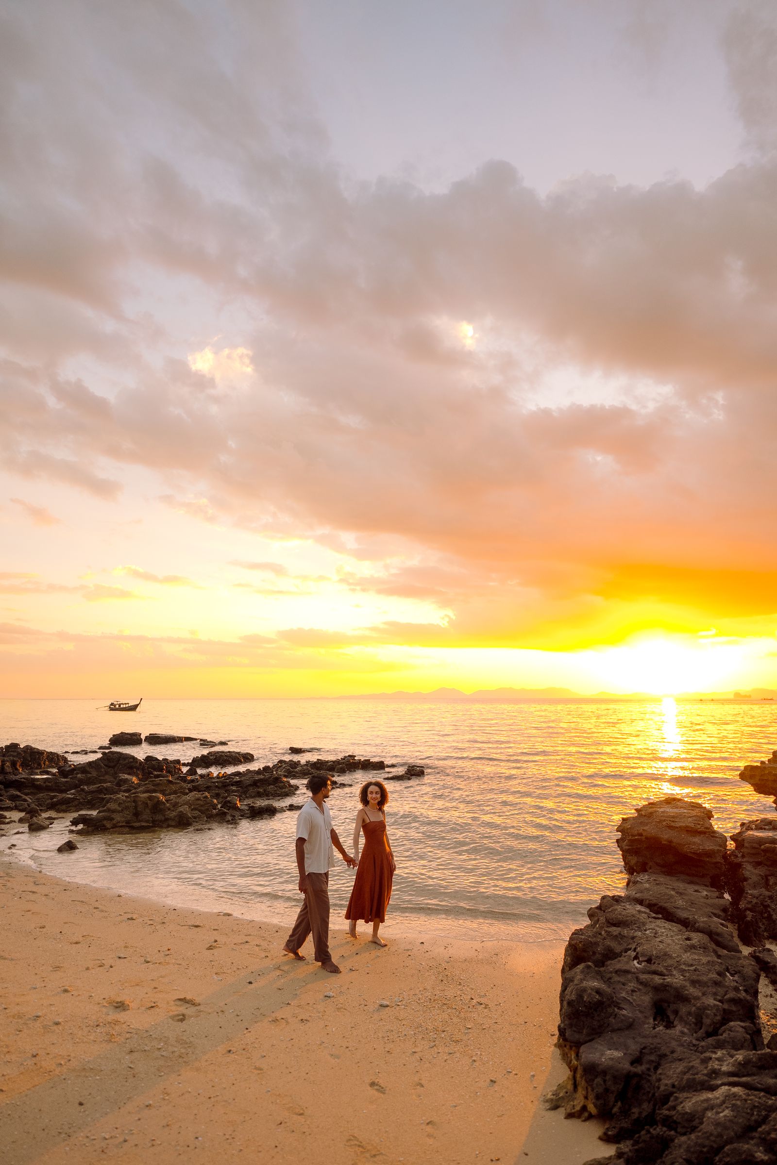 Larissa and Nihal walking hand in hand on the beach